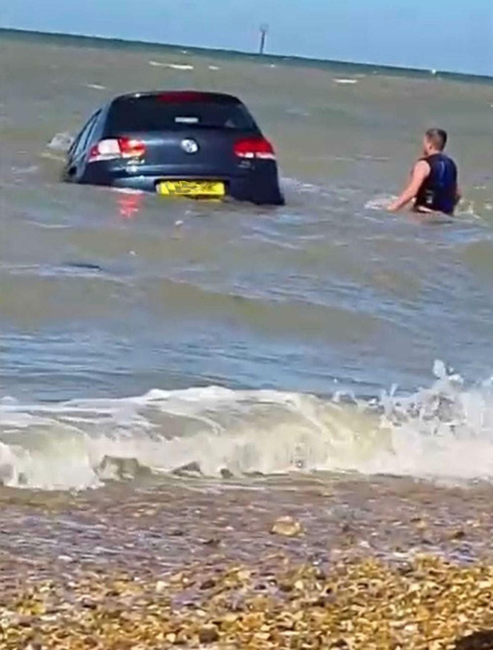 bystanders help man to save his car that got swept off into the sea