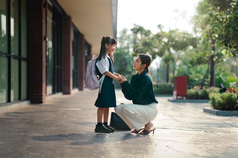一位母亲拉着女儿你的手