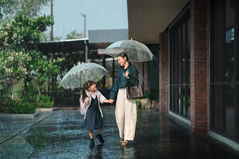 母女撑伞漫步雨中